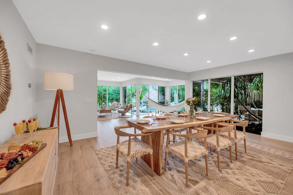 The dining room comfortably seating eight features beautiful views of the outdoor landscape overlooking the living room.