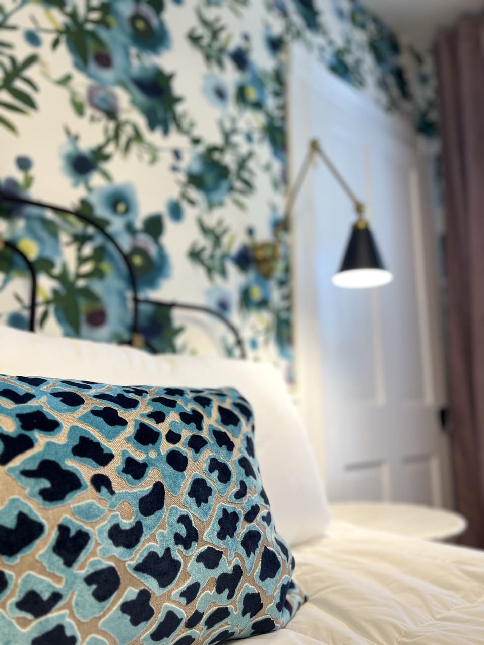 Suite 1: Private entrance with semi-private porch or additional optional entry through hallway, King Anthropologie bed, 50" Smart TV, porcelain tile bath, and option to adjoin with Suite 2. 