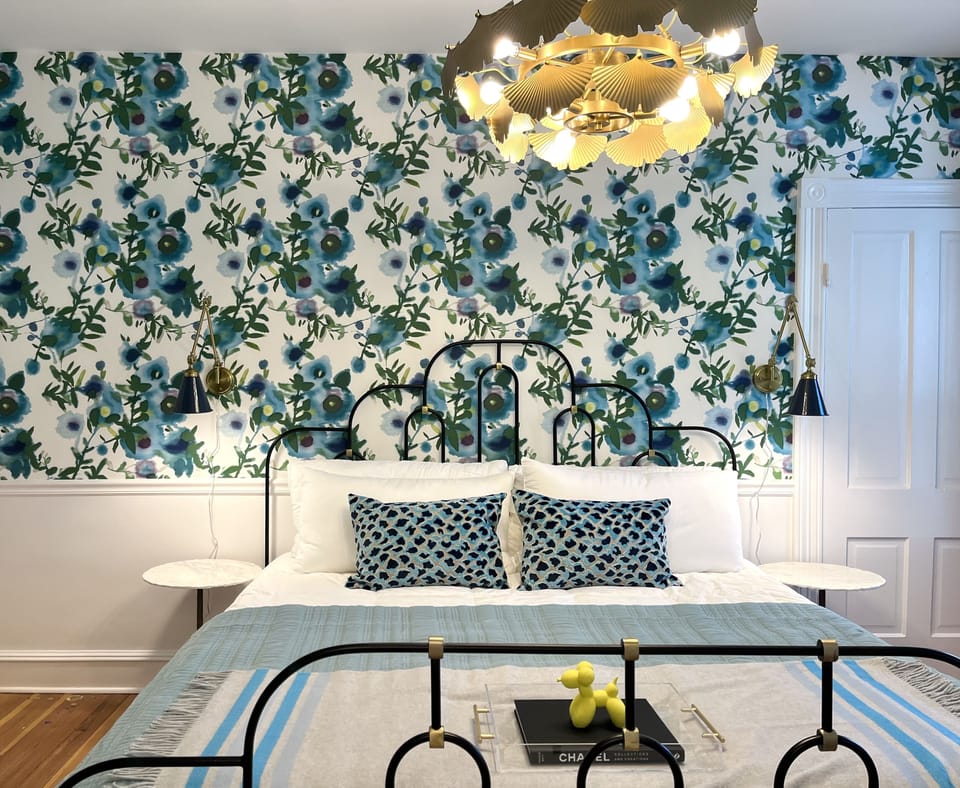Suite 1: Private entrance with semi-private porch or additional optional entry through hallway, King Anthropologie bed, 50" Smart TV, porcelain tile bath, and option to adjoin with Suite 2. 