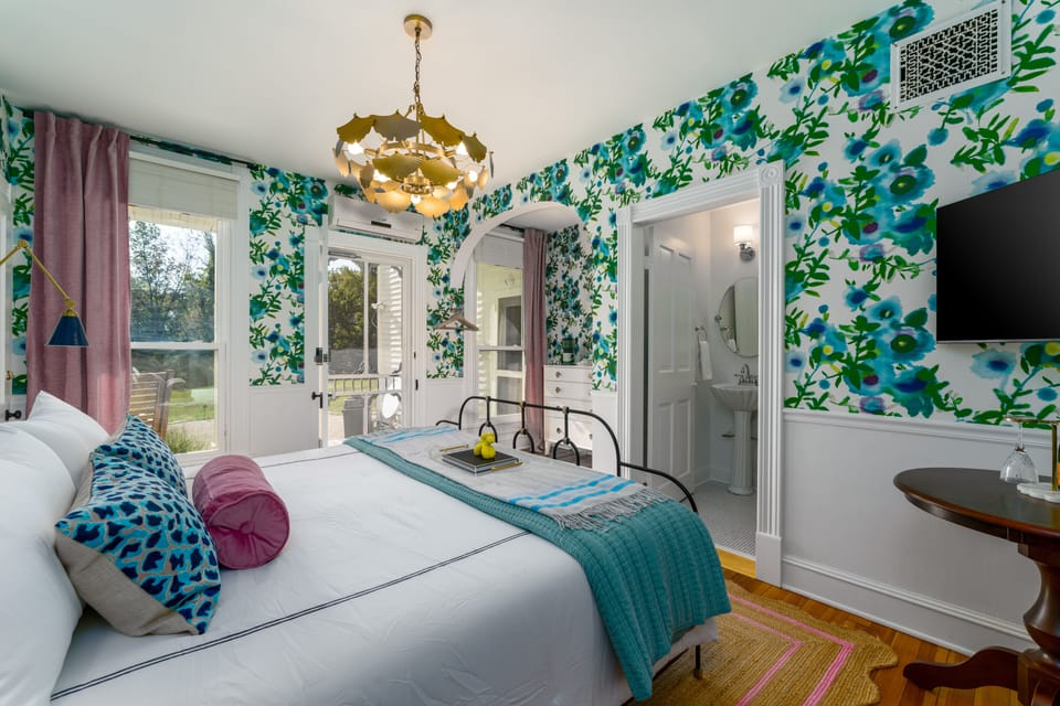 Suite 1: Private entrance with semi-private porch or additional optional entry through hallway, King Anthropologie bed, 50" Smart TV, porcelain tile bath, and option to adjoin with Suite 2. 