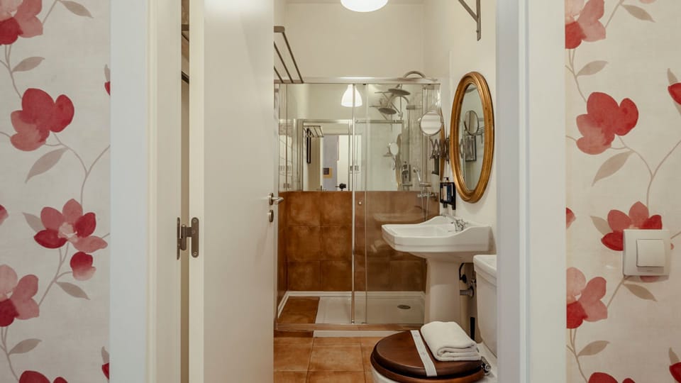 A charming bathroom with modern fixtures. The glass shower and elegant round mirror add a touch of sophistication #design #modernliving #lisbon #pt #portugal