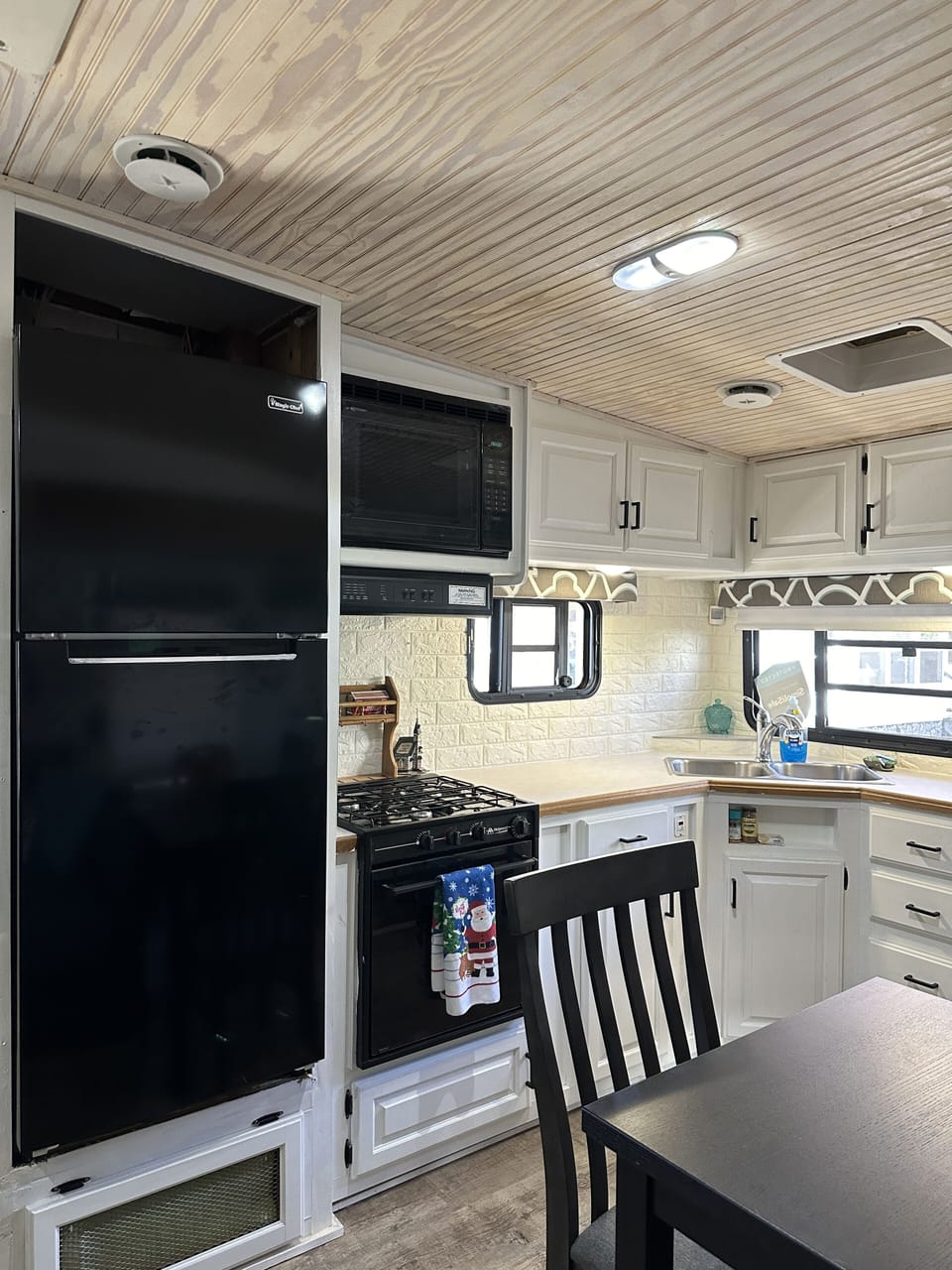Kitchen with large refrigerator, stove and microwave