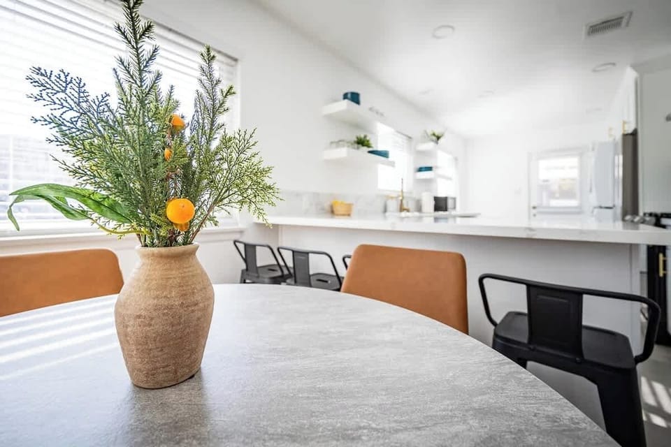 Dining Area: Clean and refreshing dining space with a high chair, great for family gatherings or quiet mornings.