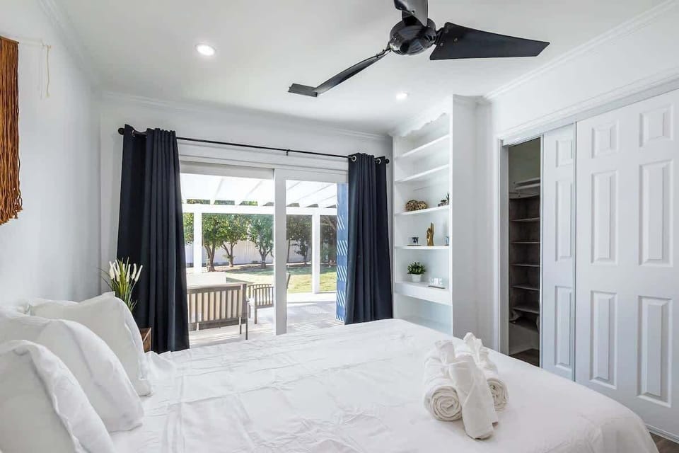 Bedroom 1: Bright and airy space with large doors opening to the outdoors, allowing natural light and fresh air to flow in for a relaxing stay.