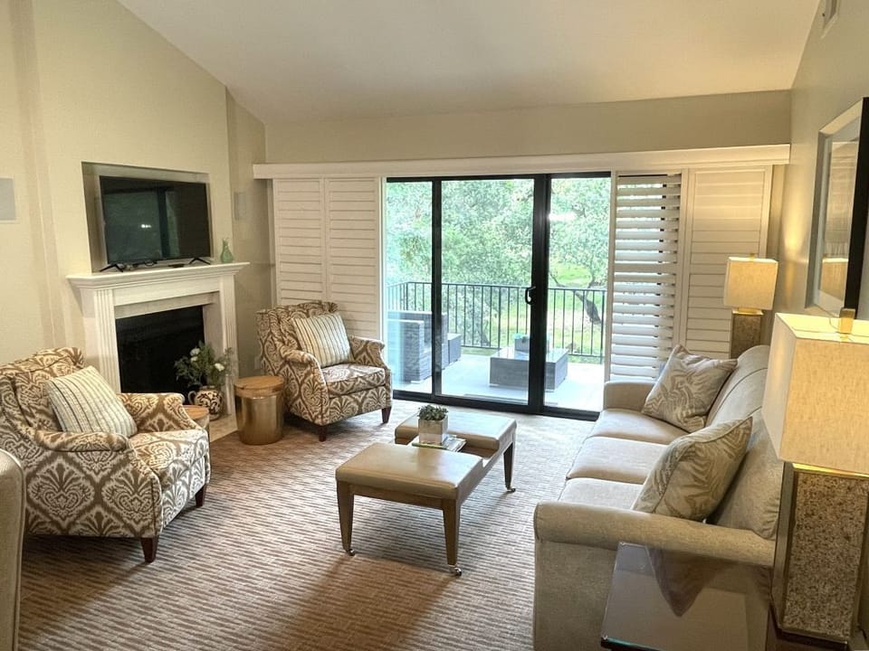 Living room with TV, fireplace, sofa bed, and access to the balcony