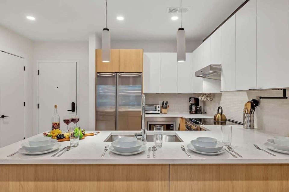 Fully equipped modern kitchen stocked with all culinary essentials and featuring brand new stainless steel appliances with bar seating.