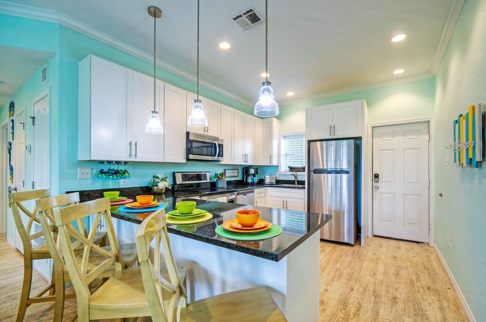 Fully equipped kitchen with barstool seating at the counter.
