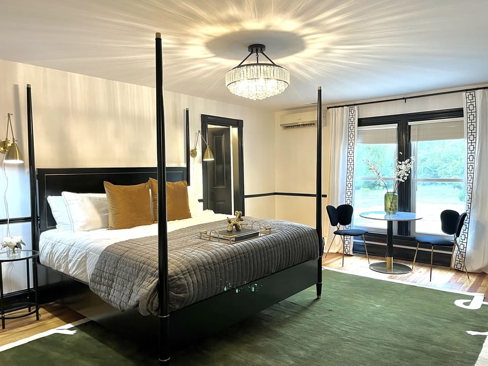 Suite 4: King bed, Daybed, Table with 2 chairs for meals or WFH, 55" Smart TV, marble tile bath, and views of the lawn.