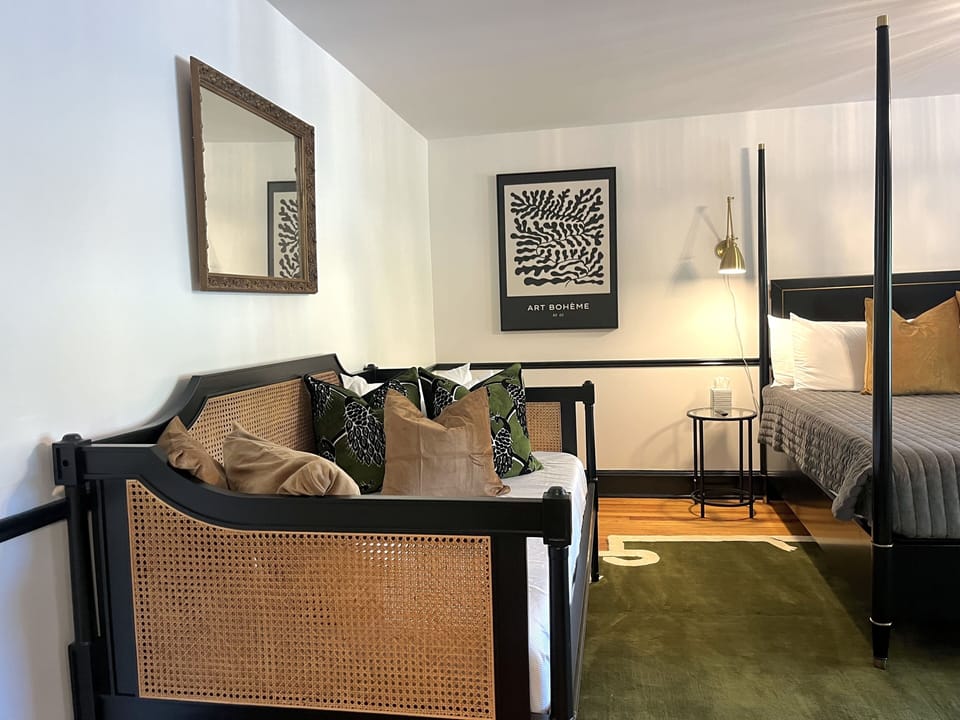 Suite 4: King bed, Daybed, Table with 2 chairs for meals or WFH, 55" Smart TV, marble tile bath, and views of the lawn.