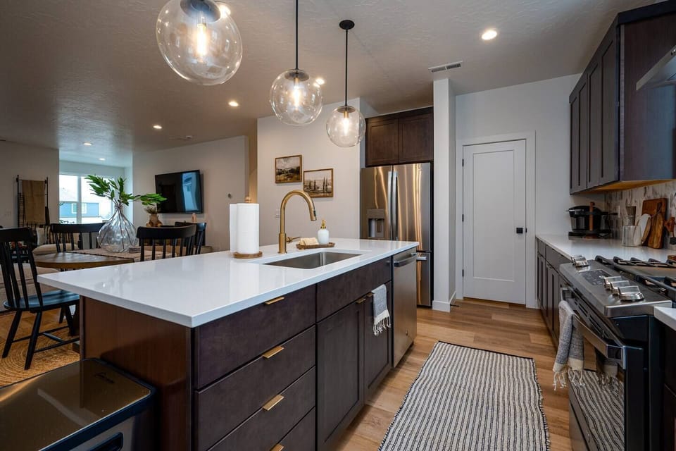 With its modern lighting, windows, quartz countertops, and stunning backsplash, the kitchen makes preparing dinner a truly enjoyable experience.