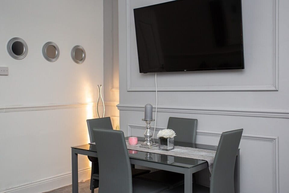 The dining table, with its sleek lines and ample seating, beckons guests to gather for memorable meals or lively conversations.