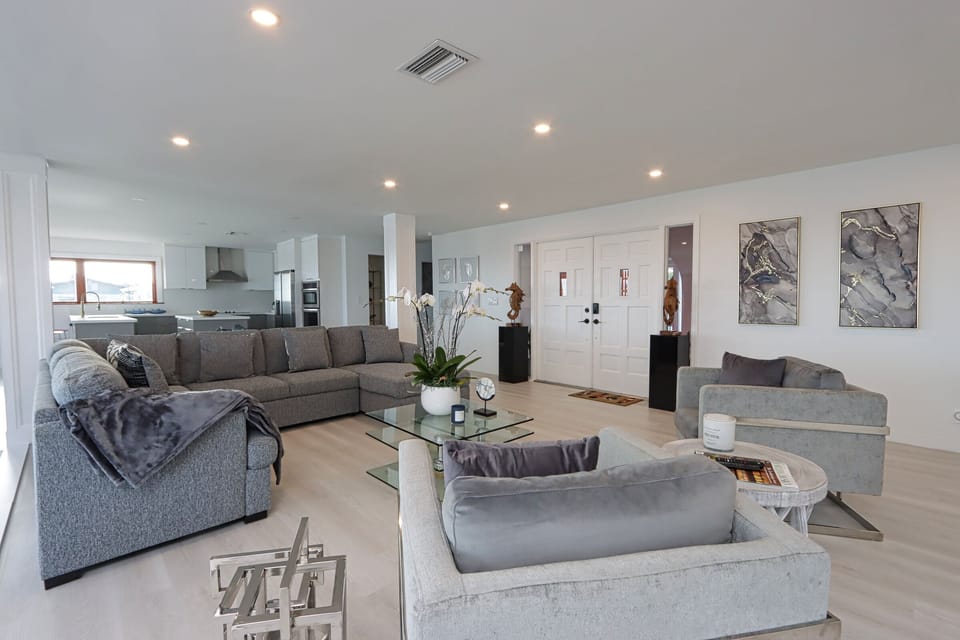 The open-concept living room invites you to relax with plenty of seating on the plush sectional or oversized chairs — perfect for gathering with family and friends