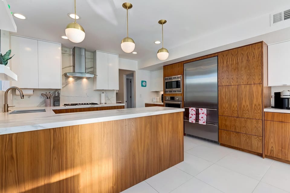 Step into a chef's paradise with this stylish, well-appointed modern kitchen. Featuring stainless steel appliances, sleek countertops, & ample cabinet space, it's the perfect space to cook with family & friends, creating delicious memories together.