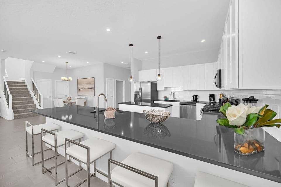 A sleek breakfast bar invites quick snacks or cocktails while socializing during meal prep.