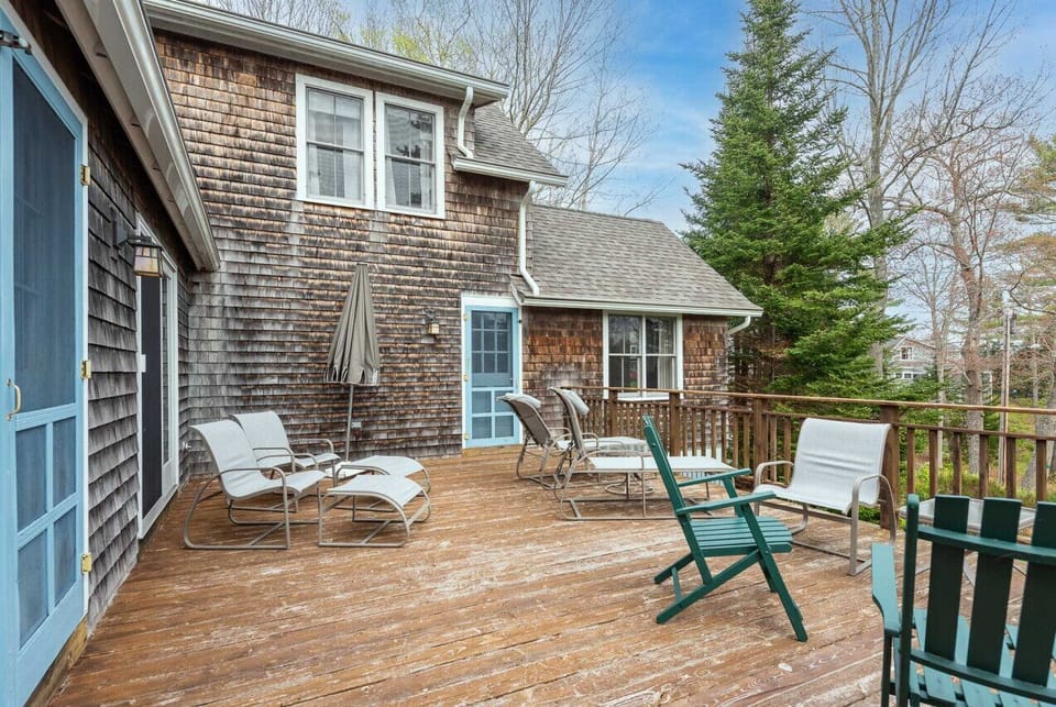 Large deck with access points through the living room, sunroom, and primary bedroom