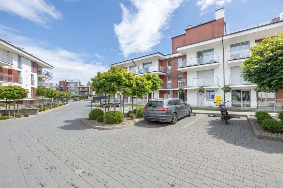 An exterior view of the residential complex with neatly arranged pathways and parking spaces.

