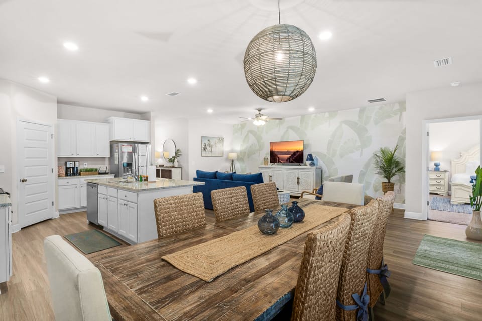 Spacious open concept living and dining with rustic table and modern kitchen