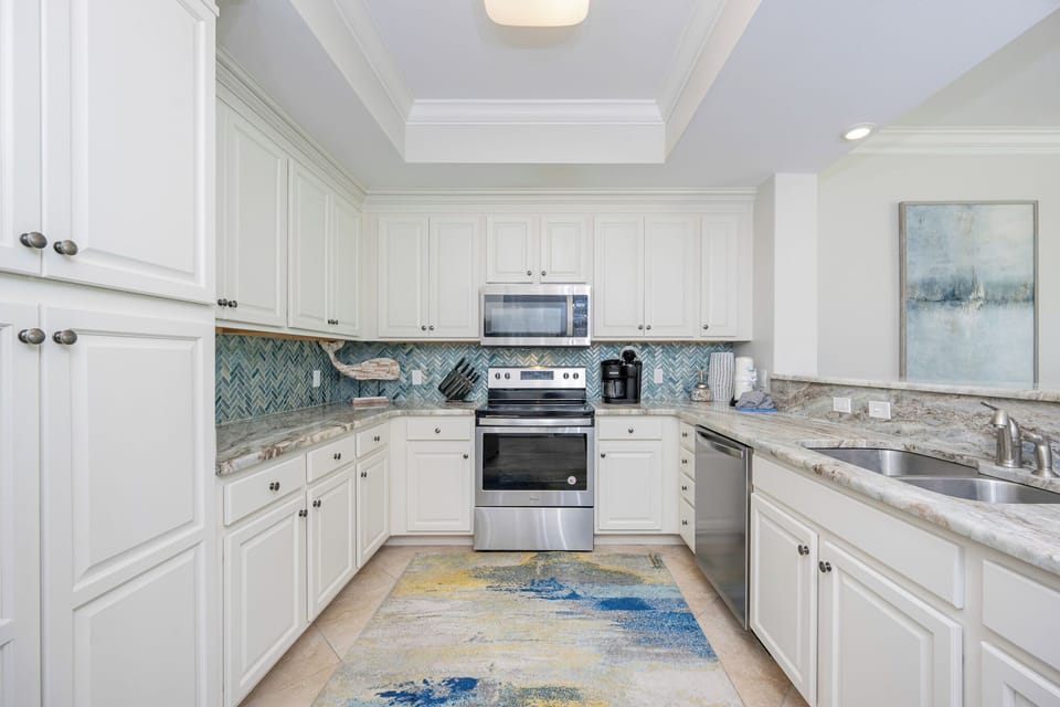 Prepare meals in this kitchen with elegant cabinetry, stainless appliances, and stylish backsplash