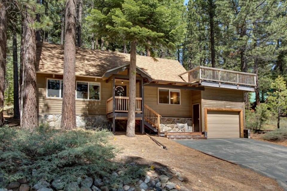 Charming cabin exterior surrounded by towering pines, offering a peaceful and private retreat.