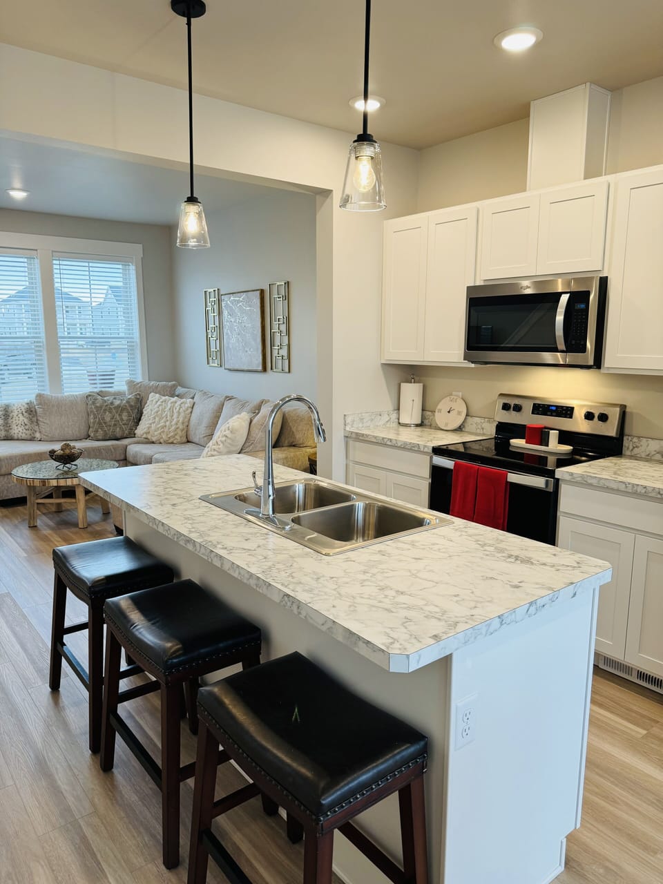 Full kitchen with breakfast bar island with three bar stools.