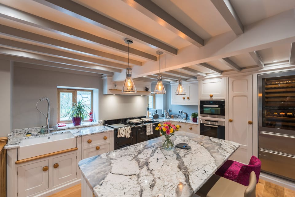 kitchen with Aga, breakfast bar seating, electric oven. microwave and wine cooler