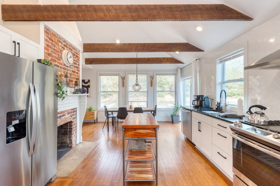 Kitchen features a rustic fireplace and modern appliances.