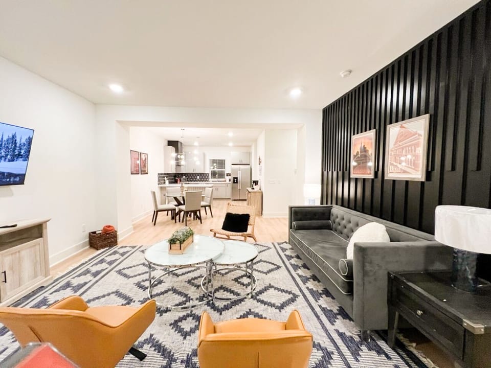 OPEN FLOOR PLAN LIVING ROOM – Step into this stylish, open-concept living and dining area, complete with modern furnishings, a plush sofa, and a 52" flat-screen TV,  ideal for a comfortable and inviting stay in Nashville!