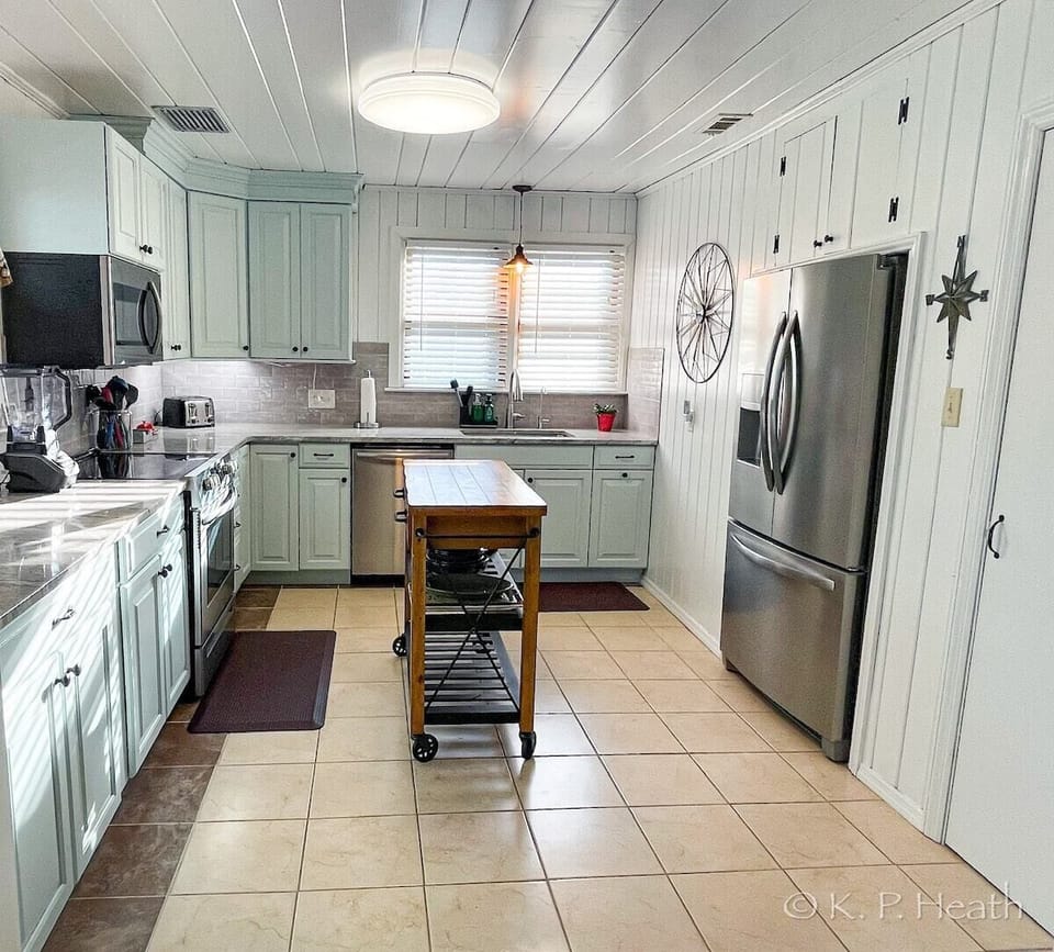 Spacious cook's kitchen equipped with center island, fully stocked.