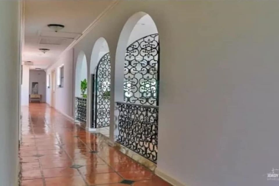 Beautiful Hallways with wrought iron patterned gate to the family living room.