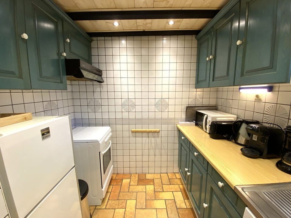 Kitchen with fridge, stove, microwave, coffee maker, kettle, dishwasher