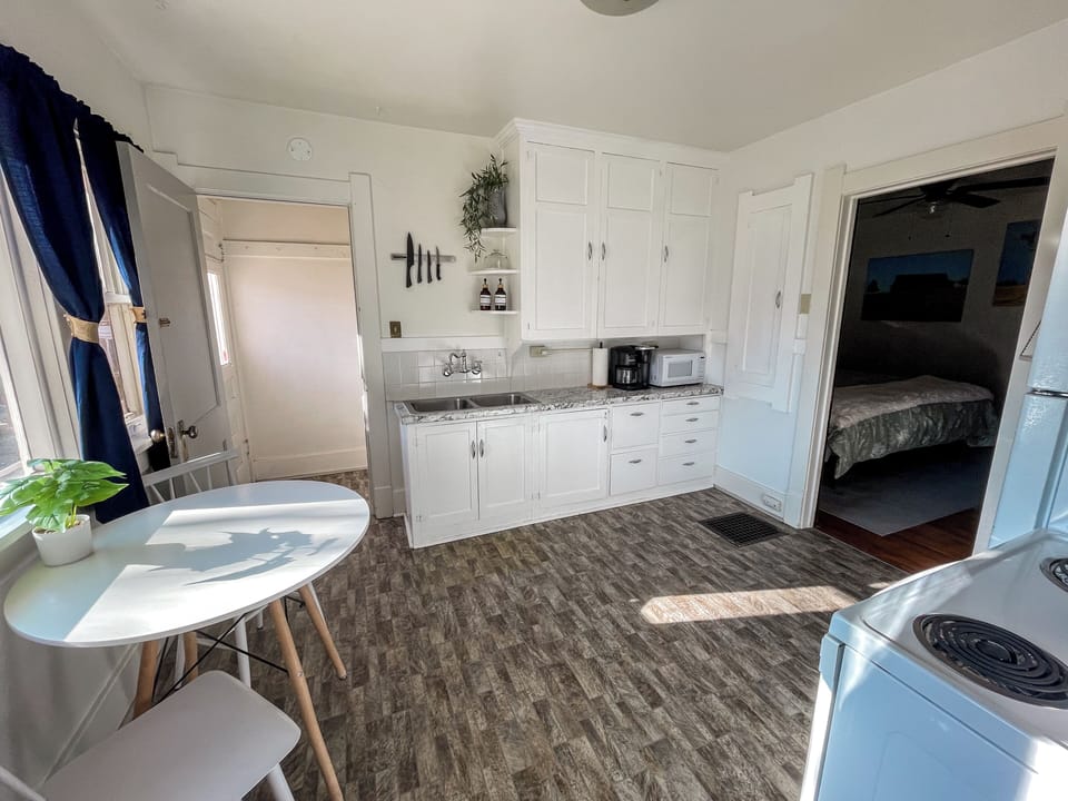 Bright eat-in kitchen with sunny windows, coffee station, and charming style