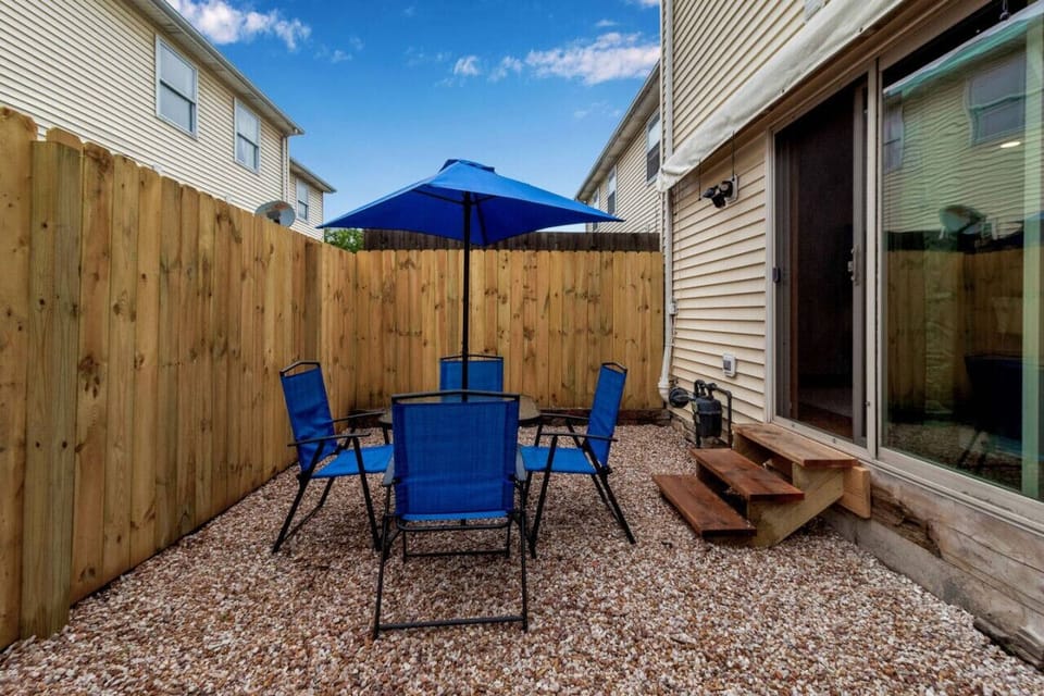Private Rear Patio, accessible from Living Room with table, chairs, and umbrella