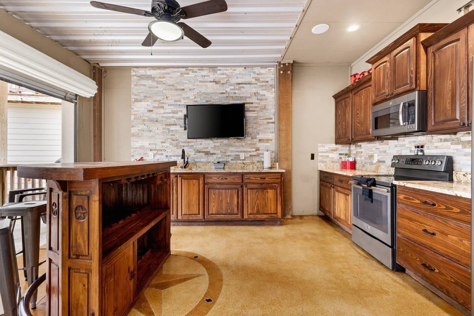 Seamlessly blend indoor and outdoor living with garage doors that open to reveal an inviting outdoor kitchen, complete with a TV.