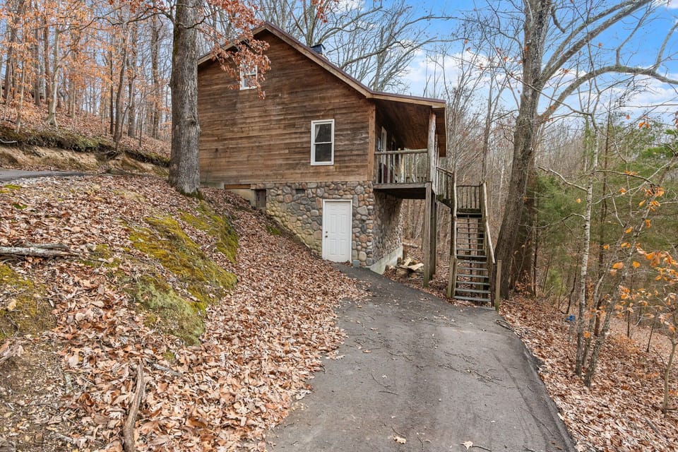 Rustic cabin exterior on a hillside, a charming retreat in a natural setting.