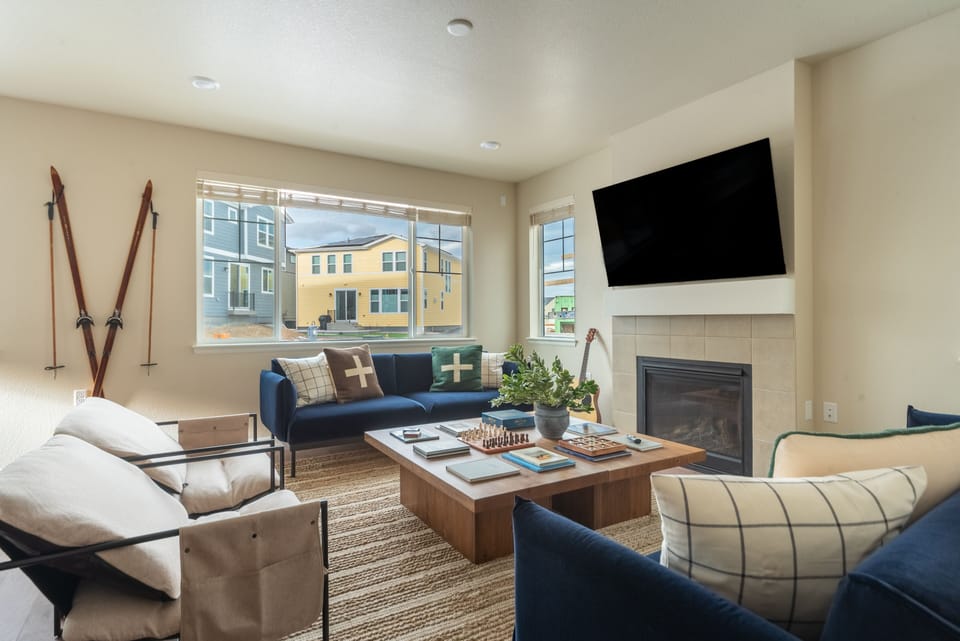 Living room with TV, windows, and board games