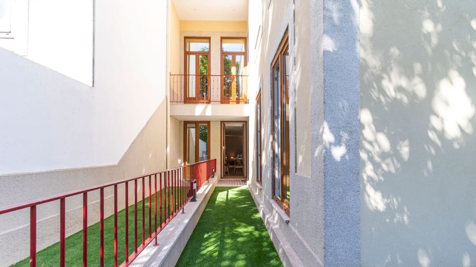 Discover your serene pathway home, a charming outdoor corridor lined with lush artificial grass and a modern railing leading to your private entrance. Enjoy the delightful interplay of sunshine and shadows as you approach your welcoming retreat.