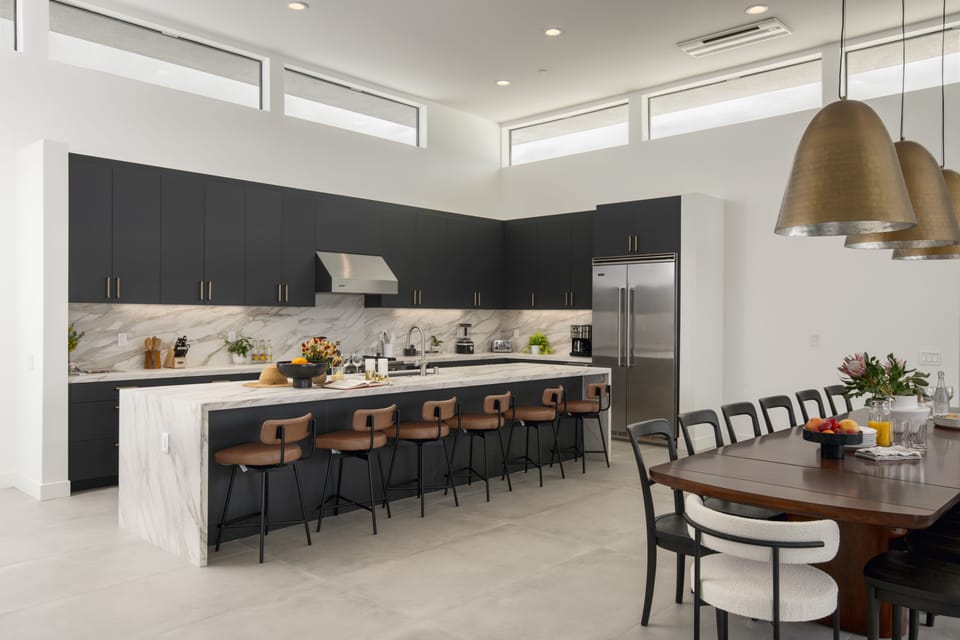 Gourmet fully-equipped kitchen with a full suite of appliances and barstool seating that opens into the dining area.