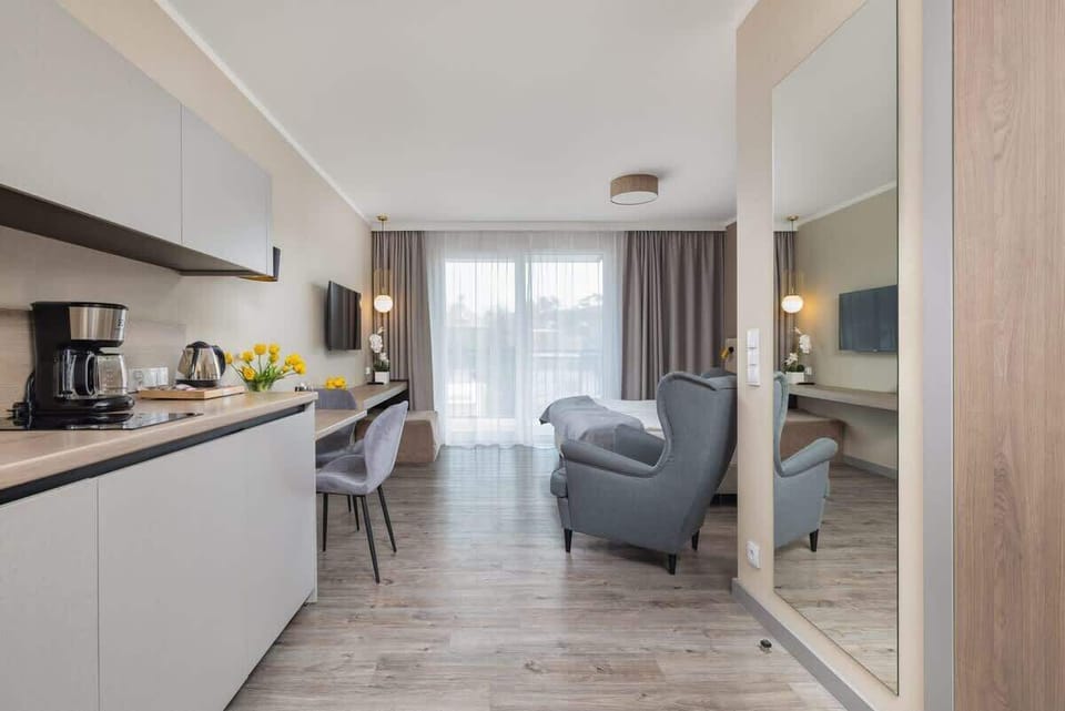 Open-plan living area with kitchenette, dining set, and comfortable seating.
