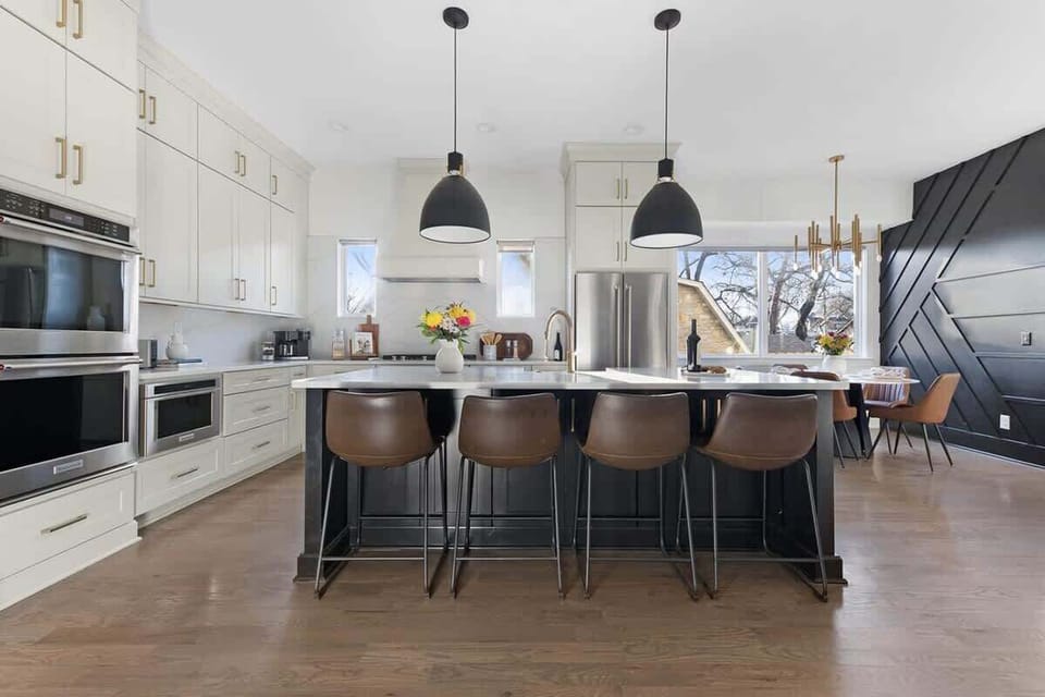 Clean and Spacious Kitchen with Sleek Countertops and Additional Seating