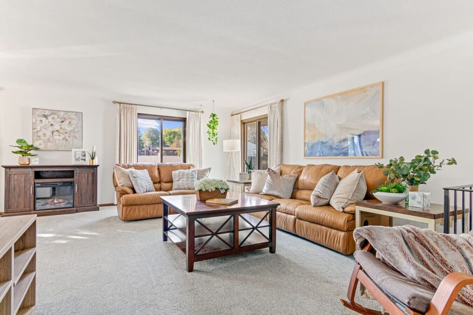 Step into this sun-drenched living room at Minne-Getaway: Kraft Gallery, creating a warm & inviting ambiance. The cozy sofa and loveseat provide the perfect spots to relax, unwind, and enjoy the comfort of home.
