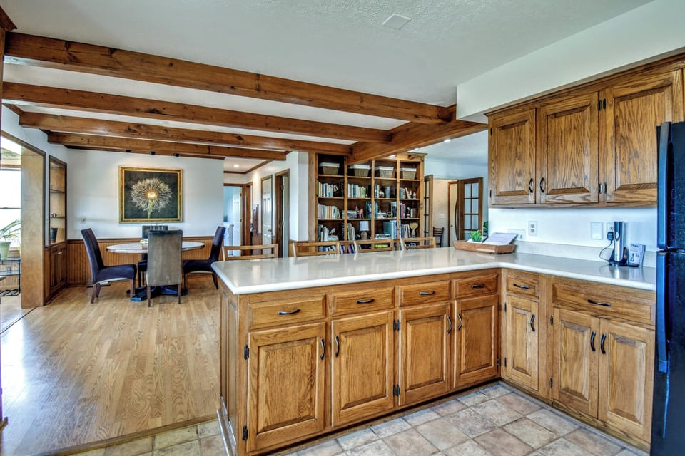 Kitchen looking to breakfast/lunch bar, dining area and library shelves. 