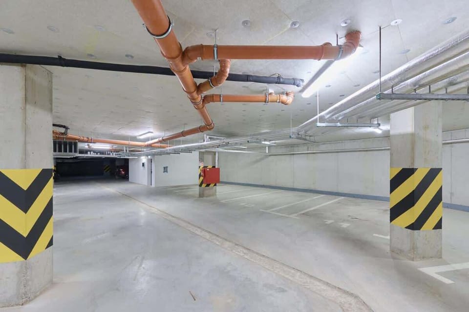 Underground parking with bright lighting and safety markings.
