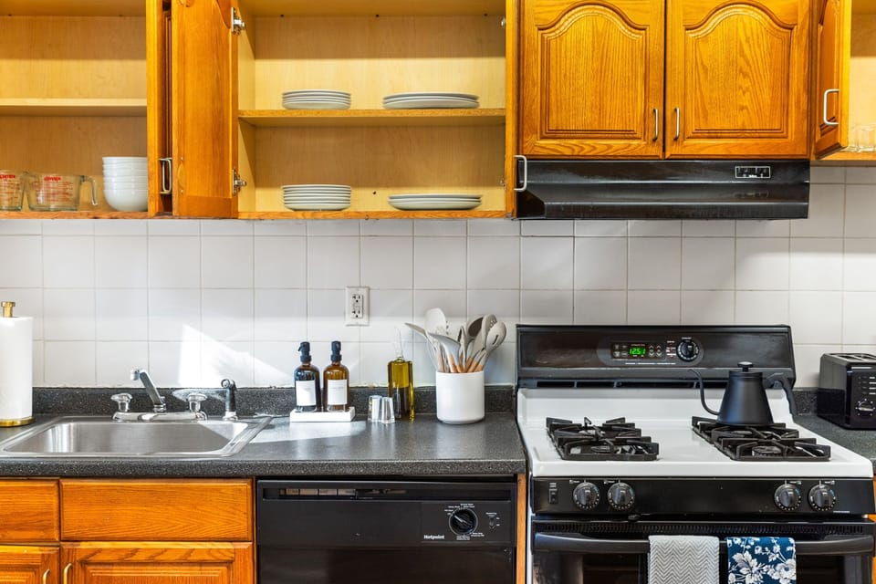 Kitchen stocked with a comprehensive array of cookware and dinnerware