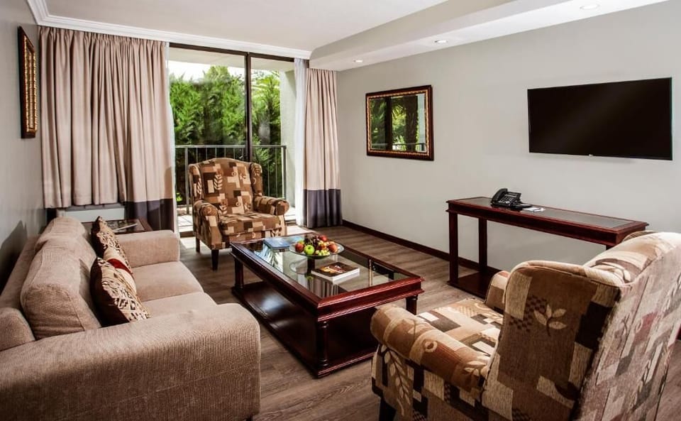 Unwind on plush sofas with calming garden balcony views.