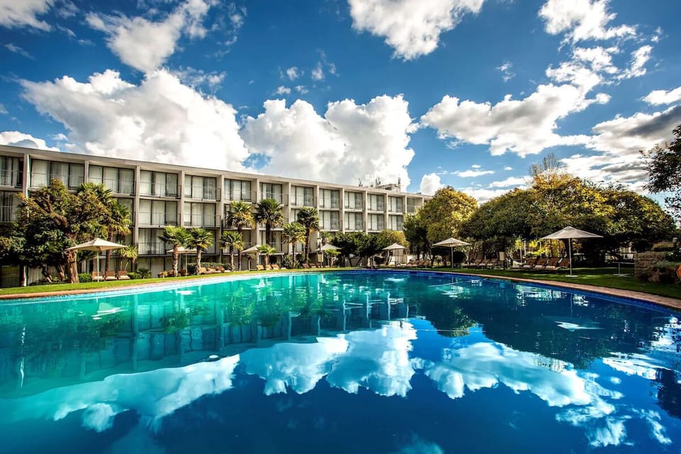 Soak up sun by the mirror-calm pool under blue skies.