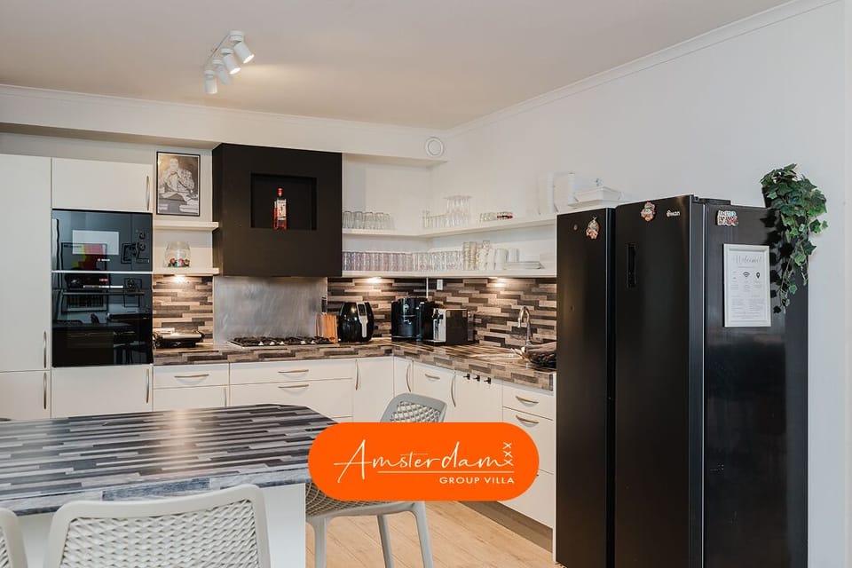 The kitchen includes two ovens, a microwave, a dishwasher, and a coffee machine.