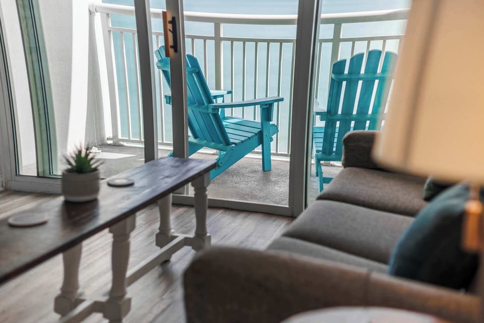 Relax in the cozy living area with direct balcony access and beautiful ocean views just steps away.