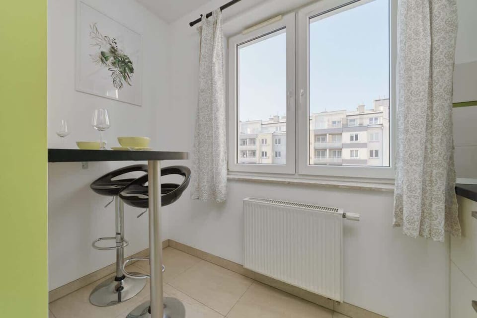 Kitchen corner with bar stools and large window.
