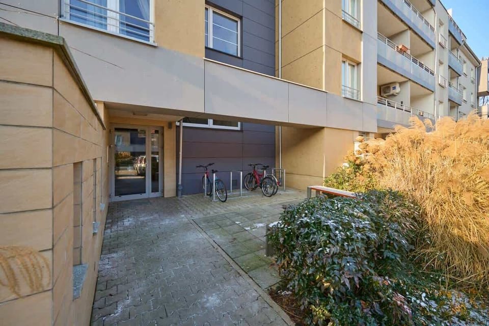 Apartment terrace with outdoor seating and surrounding greenery.

