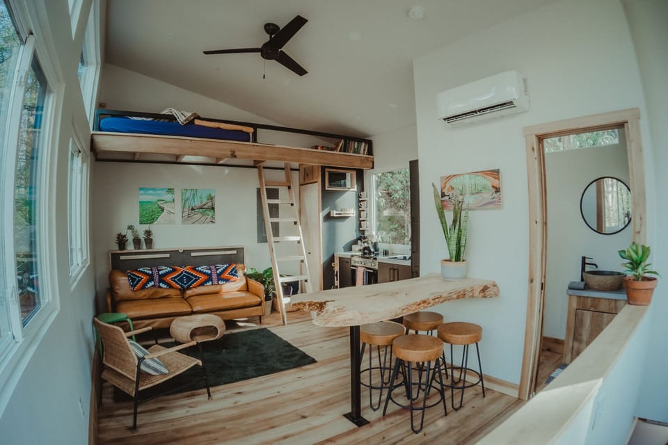 Cozy, curated living space with lofted sleeping and forest views.